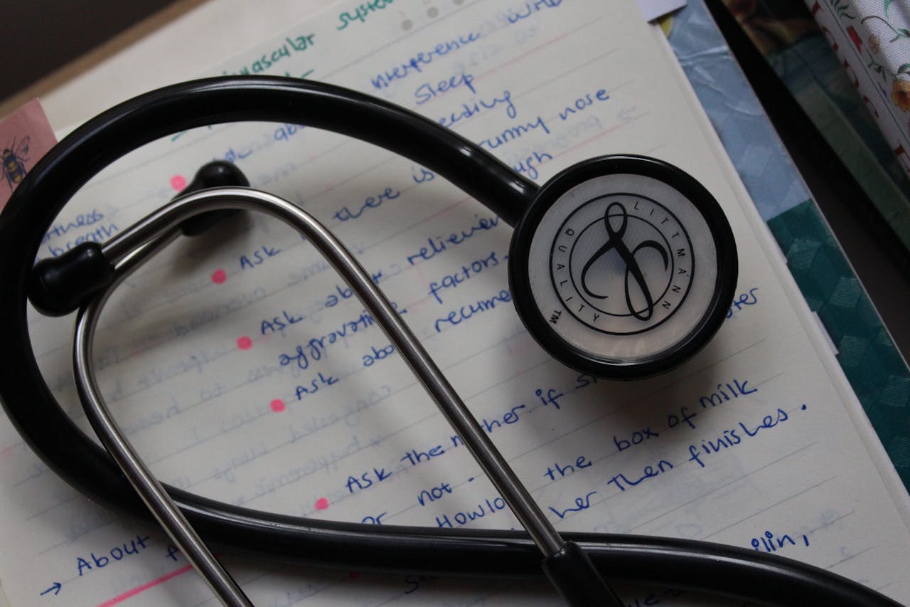 A black stethoscope on handwritten medical notes enhances a study session.